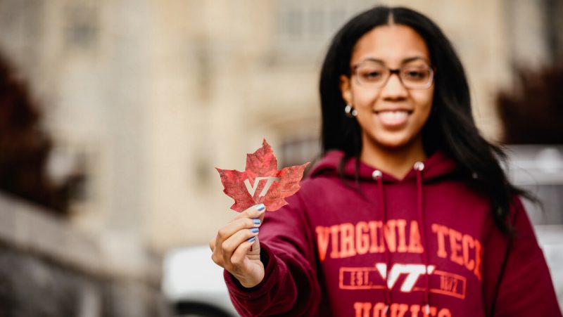 Student holding leaf with VT logo